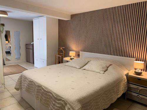 a bedroom with a large white bed in a room at Domaine Au Vert Gna ! in Saint-Hostien