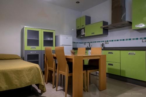 a kitchen with green cabinets and a table and chairs at Hotel Macami in El Carpio