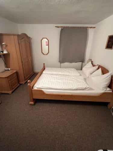 a bedroom with a large bed with white sheets at Ferienwohnung Zschopautal in Mittweida
