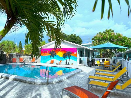 une piscine avec une fresque colorée à côté d'une maison dans l'établissement Park Shore Suites St Pete Beach, à St. Pete Beach
