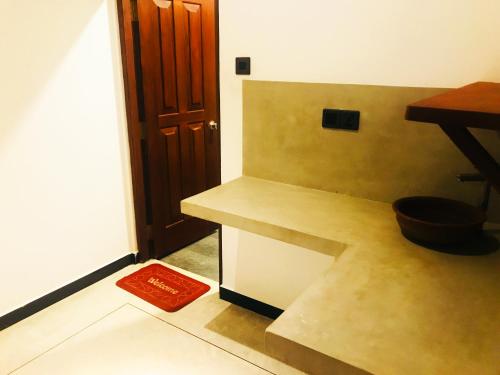 a kitchen with a counter and a bowl on the floor at Chamara Inn in Talpe