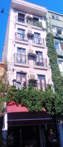 a tall white building with plants growing on it at Taksim City ivy Hostel in Istanbul