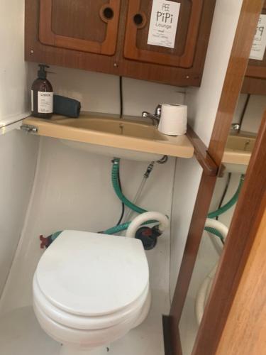 a small bathroom with a toilet in a room at Vintage sailboat experience in Lisbon