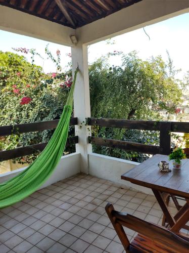 a hammock on a porch with a table and bench at Get Up Hostel in Natal
