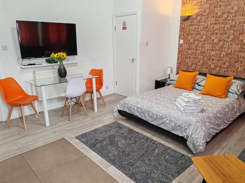 a bedroom with a bed and a table and chairs at Kilburn High Road Studio apartments in London