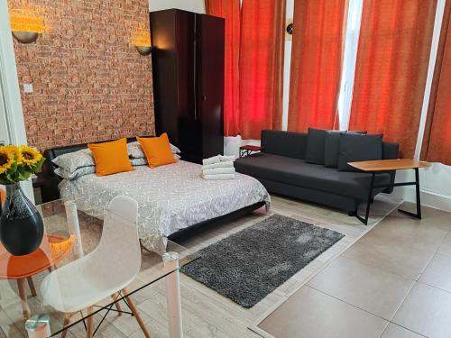 a living room with a bed and a couch at Kilburn High Road Studio apartments in London