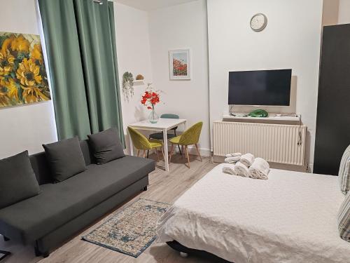 a living room with a couch and a table at Kilburn High Road Studio apartments in London