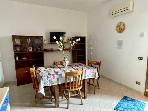 a dining room table with a vase of flowers on it at Casa Vacanze - Da Peppina in Petrosino