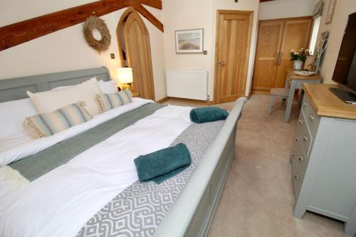 a bedroom with a large white bed with green pillows at The Chapel - A Hidden Gem with Private Pool & Bar in Stone