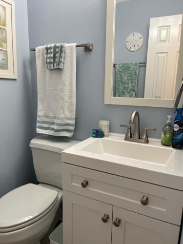 a bathroom with a toilet and a sink and a mirror at Cherry Grove condo just steps from the ocean in Myrtle Beach