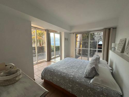 フロンテーラにあるCasa Villamaravilla I, Isla de El Hierroのベッドと大きな窓のある寝室