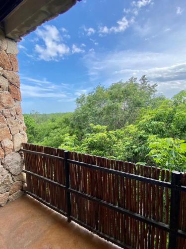 a balcony with a fence and a view of trees at Luxury Jungle Penthouse with Private Rooftop Pool in Chemuyil