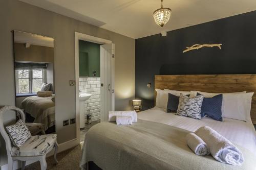 a bedroom with two beds and a chair at Church House Inn, Churchstow in Kingsbridge