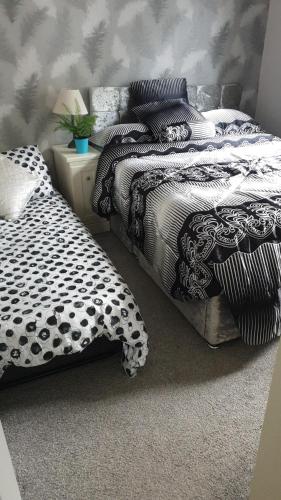 een slaapkamer met 2 bedden met zwart-witte lakens bij Unique 2 bed lodge in Rhyl