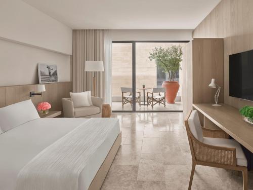a hotel room with a bed and a desk and a chair at The Bodrum EDITION in Yalıkavak