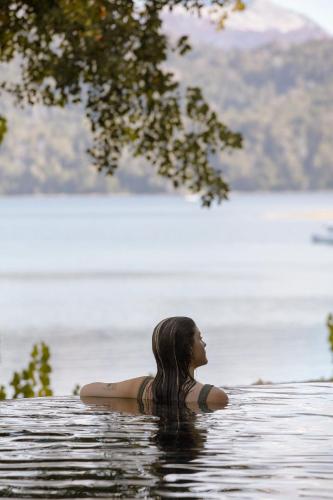 a woman sitting in a body of water at Las Balsas Relais & Chateaux in Villa La Angostura