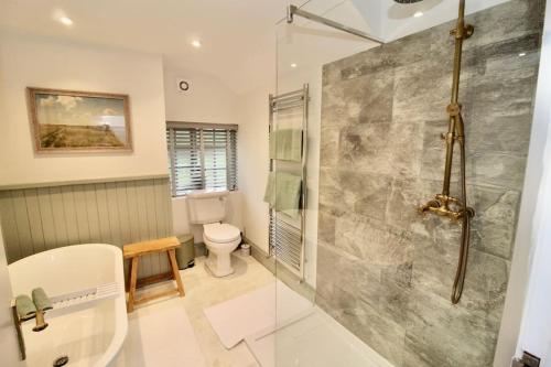 un bagno con doccia e WC di Charming retreat with hot tub and lake terrace a Hilderstone