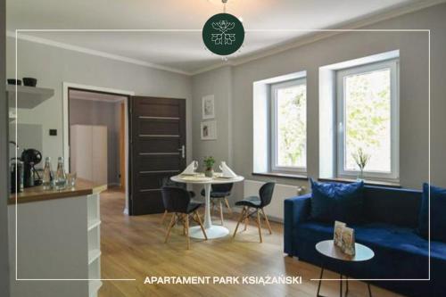 a living room with a blue couch and a table at Apartamenty przy Zamkowej w Wałbrzychu in Wałbrzych