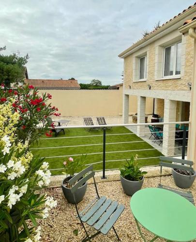 a patio with a table and chairs and flowers at Gîte Ô Pallinois Proche du Futuroscope de Poitiers in Boussais