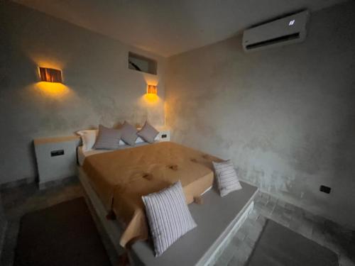 Un dormitorio con una cama con almohadas blancas. en Refuge Vert à 15 min de Marrakech, en Marrakech