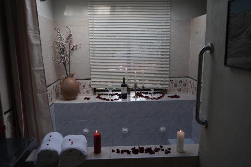 a bathroom with a bath tub with candles and a window at Casa Jazmín Hospedaje Familiar Eco Amigable - Huayoccari, Sacred Valley in Huayoccare
