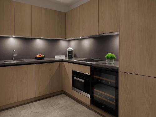 a kitchen with wooden cabinets and a sink at The Bodrum EDITION in Yalıkavak