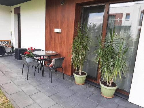 a patio with a table and chairs and plants at Green Ravine in Nałęczów