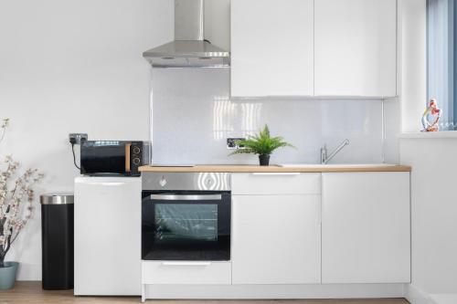 a kitchen with white cabinets and an oven at Small Studio Arnold town Center e in Nottingham