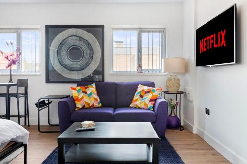 a living room with a purple couch and a table at Small Studio Arnold town Center e in Nottingham