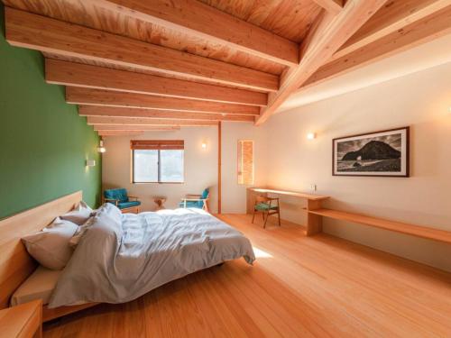 a bedroom with a large bed and wooden ceilings at Hamabe Oura - Vacation STAY 46735v in Shimoda
