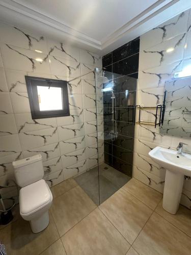 a bathroom with a toilet and a sink at BLU Apartments Sébénicoro in Bamako