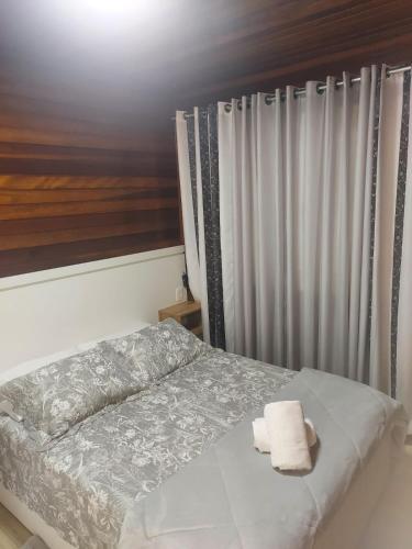 a bedroom with a bed with two towels on it at Chale Vale Carahá Lavanda in Gramado
