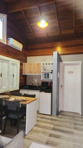 a kitchen with a white refrigerator and a table at Chale Vale Carahá Lavanda in Gramado