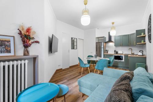 un salon avec un canapé bleu et une cuisine dans l'établissement Nice Renting - VERDI - Apartment Charm & Comfort & AirCon, à Nice