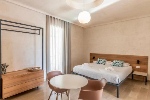 a bedroom with a bed and a table and chairs at La casa di Irene - Suites con vista in Ragusa