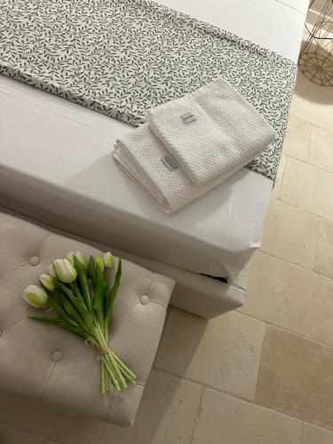 een wit bed met een bos bloemen erop bij Casa Nassiriya in Trani
