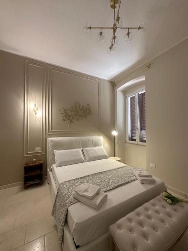 een slaapkamer met een groot wit bed en een kroonluchter bij Casa Nassiriya in Trani