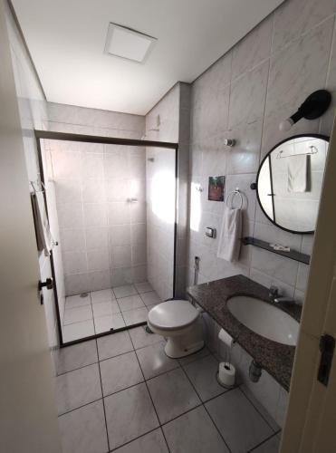 a bathroom with a shower and a toilet and a sink at Café Palace Hotel in Três Pontas