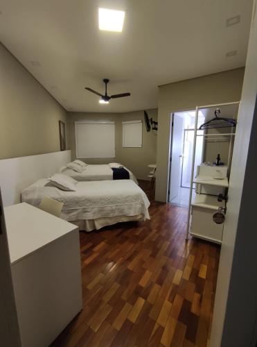 a bedroom with two beds and a bathroom with a mirror at Café Palace Hotel in Três Pontas