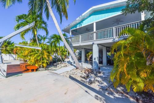 a house on the beach with palm trees at Cedar Cottage in Big Pine Key
