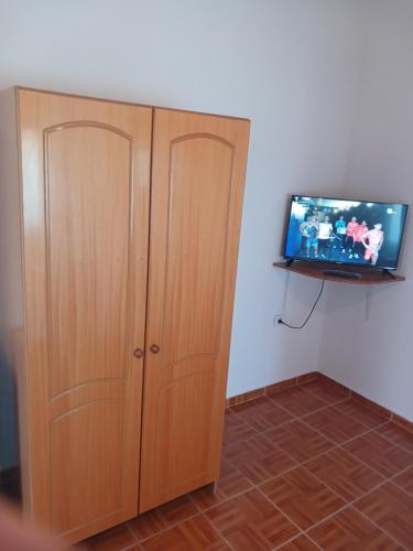 a room with a cabinet and a tv on a wall at Ari's cozy rooms, Llogara in Shalë