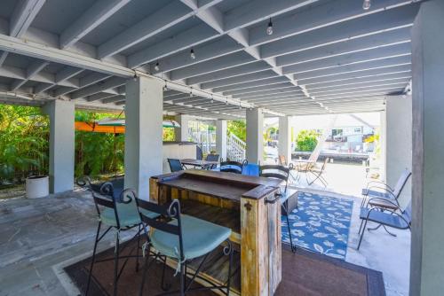 a patio with chairs and a wooden table at Cedar Cottage in Big Pine Key
