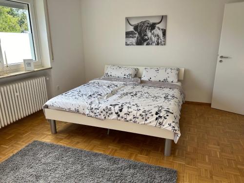 a bedroom with a bed with a cow picture on the wall at Ferienwohnung Stadtnah im grünen in Ravensburg