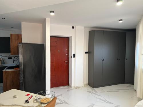 a kitchen with a red door in the middle of a room at Baie d'Alger in Husseïn Dey