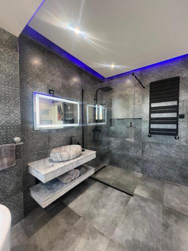 a bathroom with a shower with a sink and a mirror at Baie d'Alger in Husseïn Dey