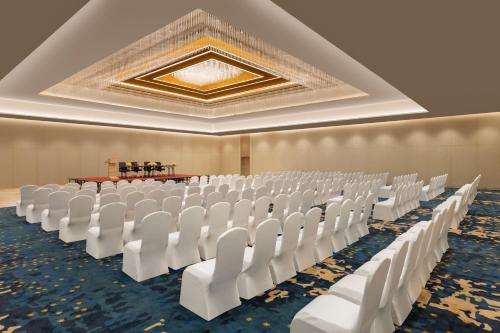 a row of white chairs in a banquet hall at Courtyard by Marriott Tiruchirappalli in Tiruchchirāppalli