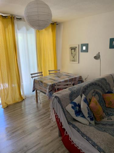 un salon avec un canapé et une table dans l'établissement Le lavandou rdj avec piscine résidence Le Lavandor, au Lavandou