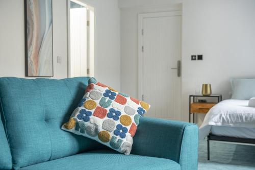 a blue couch with a pillow on it in a bedroom at Modern Studio in Central Arnold in Nottingham