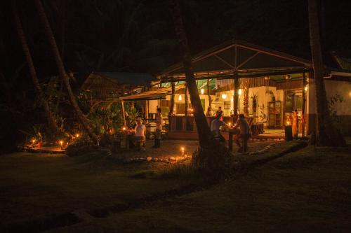 a group of people standing outside of a building at night at La Leona Eco Lodge in Carate