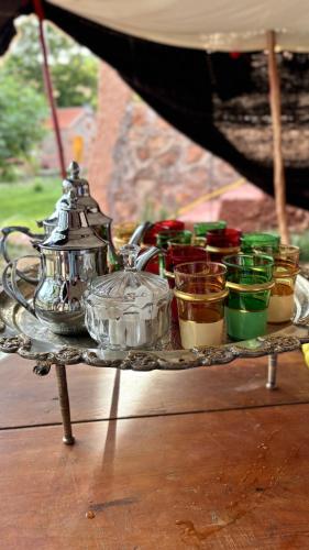 a tray with a tea kettle and cups on a table at Gite Marbie maison rurale, une expérience naturelle unique, au coeur du moyen atlas, Maroc in Kasba Tibouda